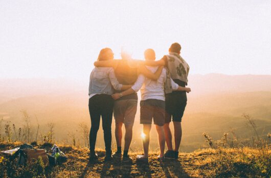 Friends standing on a hill watching sunrise - Gordon Moody