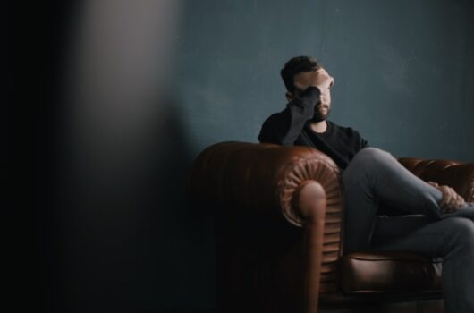 Stressed man sitting on couch